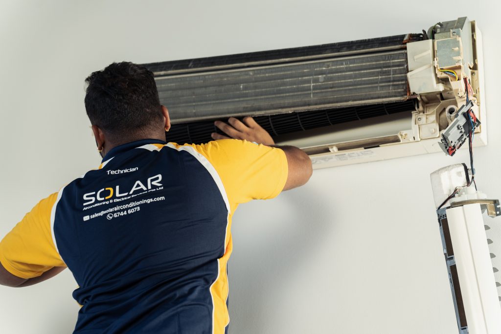 SACES technician performing fan-coil aircon chemical wash in Singapore